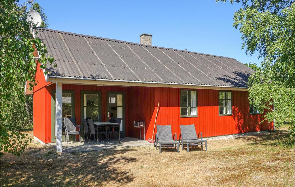 a red house with a table and chairs in front of it at Beautiful Home In Aakirkeby With 3 Bedrooms And Wifi in Vester Sømarken