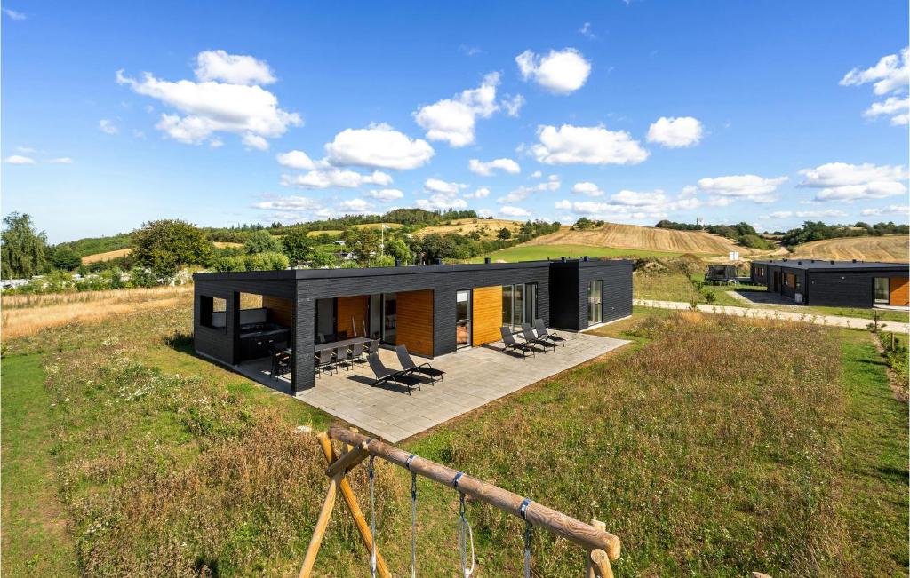 a black house on top of a grassy field at Stunning Home In Lgstrup With Wifi in Løgstrup