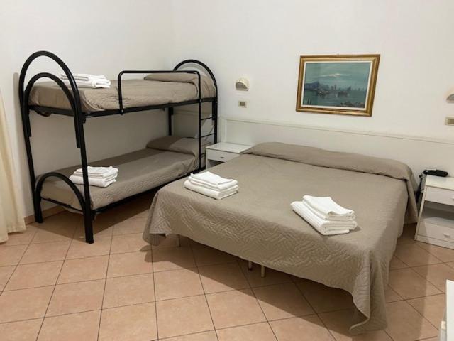 a room with two bunk beds with towels on them at Hotel Primula in Lido di Savio