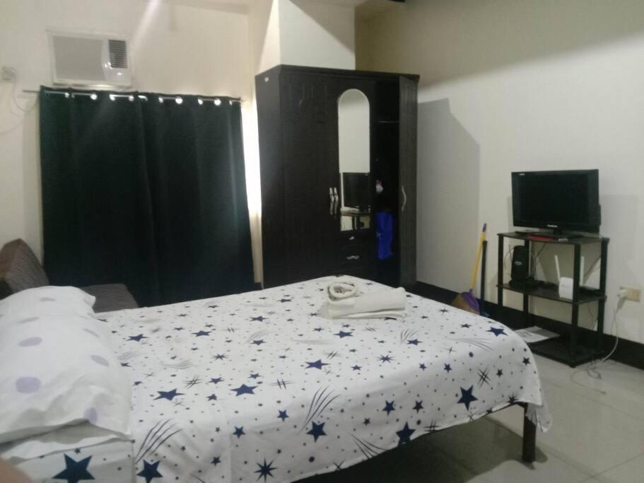 a bedroom with a bed with a blanket with stars on it at Unit Near SM City,Gaisano Mall of Cebu,Robinsons Galleria in Cebu City