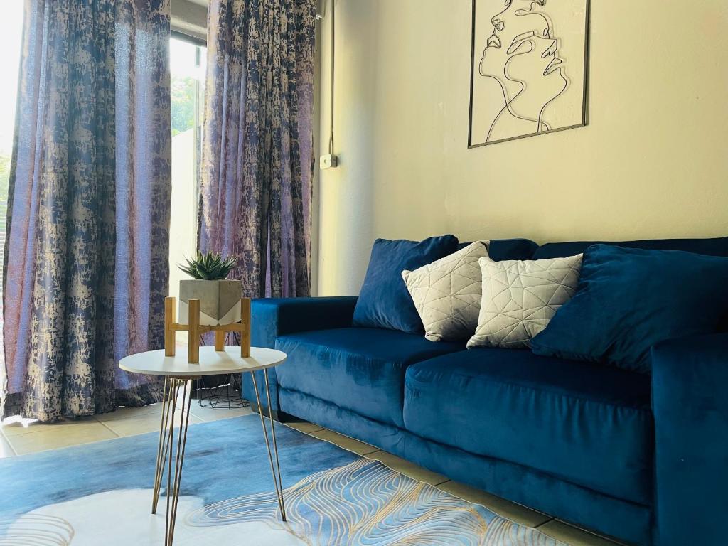 a blue couch in a living room with a table at Solace Unit in Phalaborwa