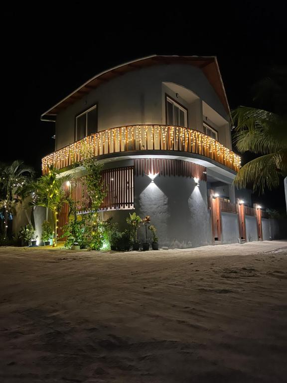 a house with lights on it at night at Finolhu Dhigurah in Dhigurah