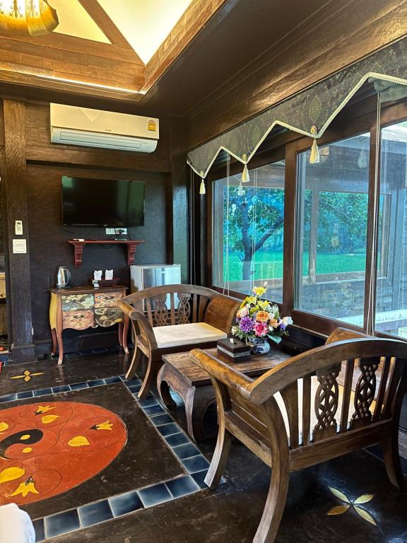 Bantunglom Resort في ماي ريم: غرفة معيشة مع طاولة وكراسي خشبية