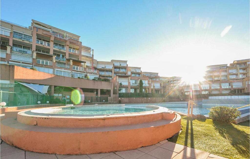 un bâtiment avec une piscine en face d'un bâtiment dans l'établissement Gorgeous Apartment In Théoule-Sur-Mer, à Théoule-sur-Mer