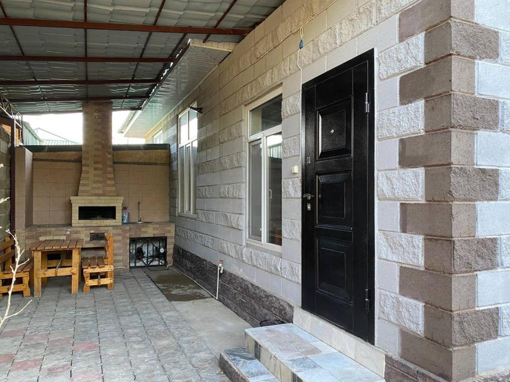 a brick house with a black door and a patio at Коттедж Чок-Тал Цо Париж 2 in Chok-Tal
