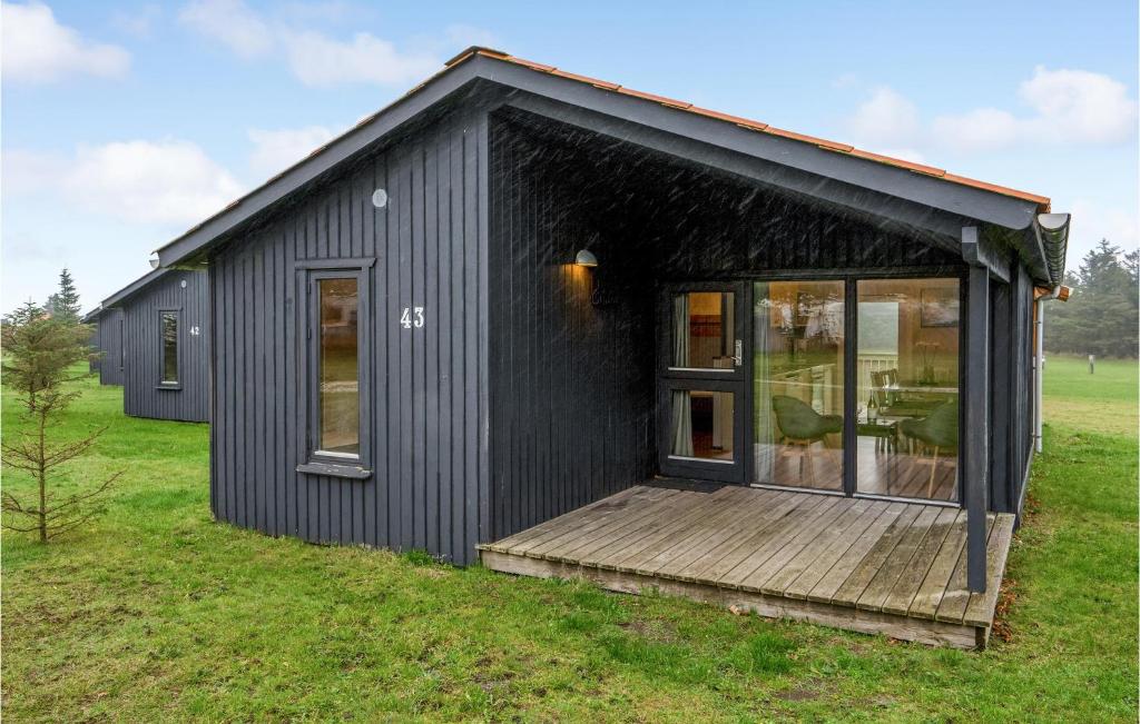 a black tiny house with a wooden deck at Pet Friendly Home In Hanstholm With Kitchen in Hanstholm