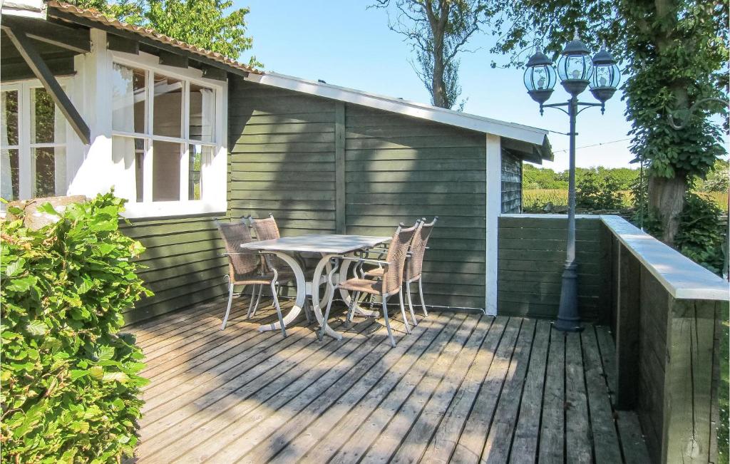 a wooden deck with a table and chairs on it at Cozy Home In Nex With Wifi in Neksø