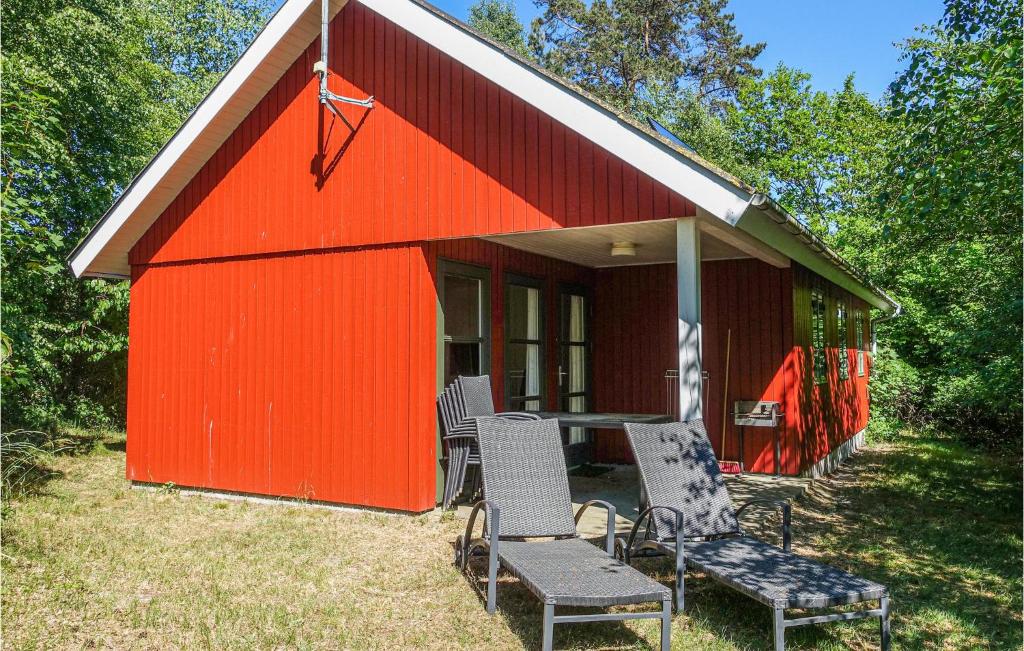 a red shed with chairs and a table in it at Stunning Home In Aakirkeby With 3 Bedrooms And Wifi in Vester Sømarken