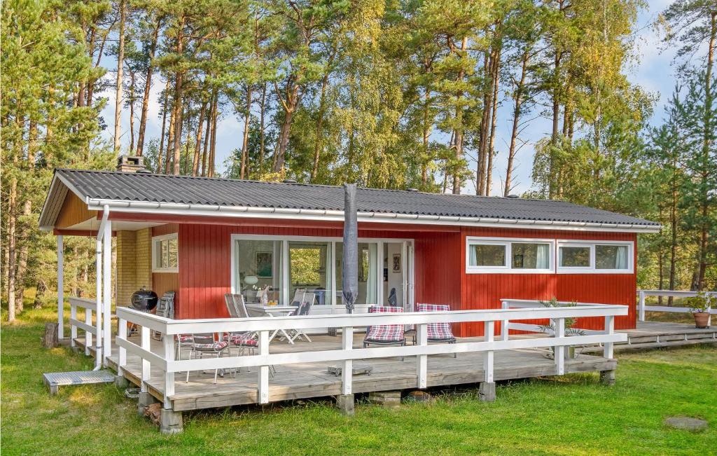 una pequeña casa roja con una gran terraza en Lovely Home In Aakirkeby With Wifi en Vester Sømarken