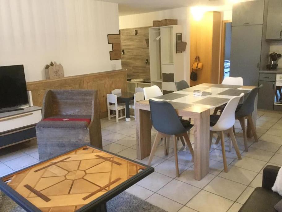 sala de estar con mesa y sillas y cocina en Magnifique appartement de montagne en Leukerbad