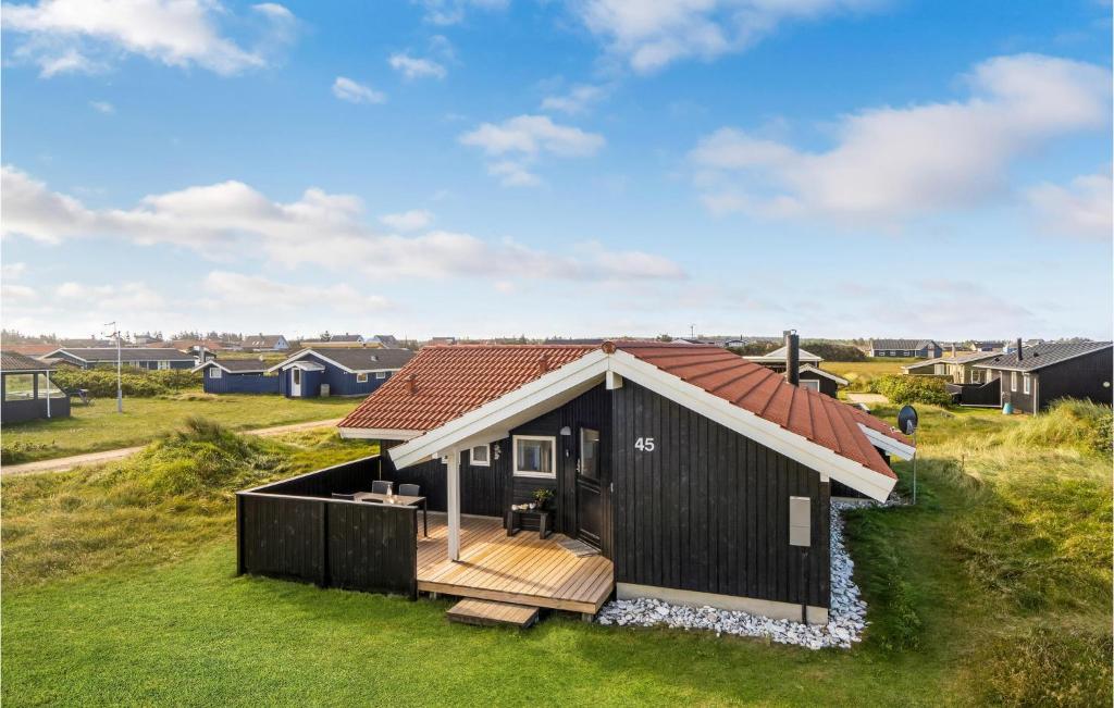 a small black house with a red roof at 3 Bedroom Stunning Home In Thisted in Torsted