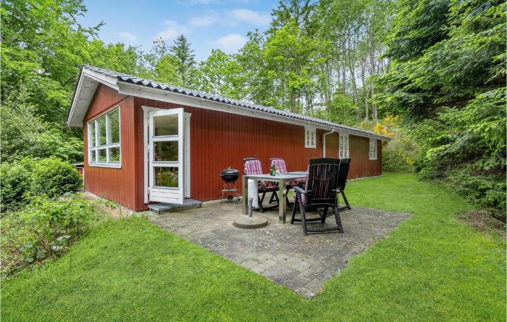 einen kleinen roten Schuppen mit einem Tisch und Stühlen in der Unterkunft Stunning Home In Gistrup With Wifi in Gistrup