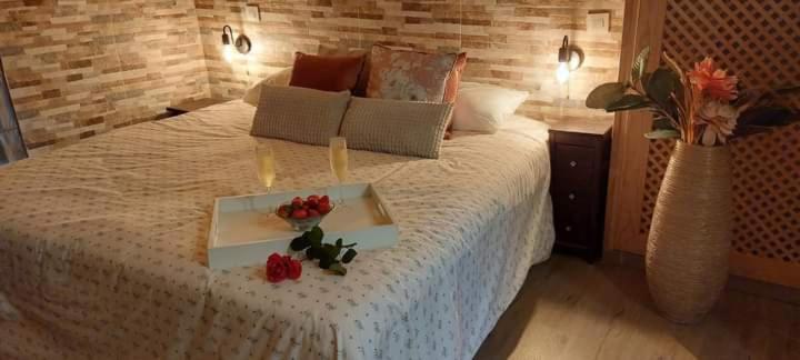 a bedroom with a bed with a tray with flowers on it at Casa Rural La Pinara in La Adrada