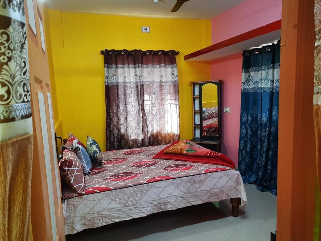 a bedroom with a bed with colorful walls and curtains at Green Land Estate Homestay 5 Rooms With Garden View in Madikeri