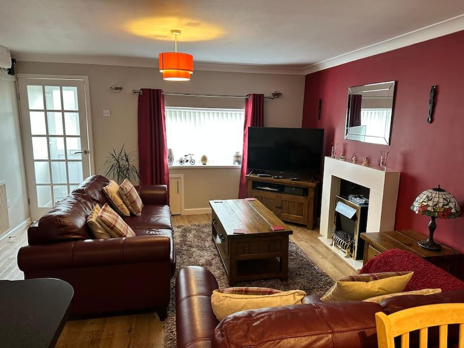 a living room with a couch and a tv at 1 Coach House - 3 bed period cottage built in 1686 in Tredegar