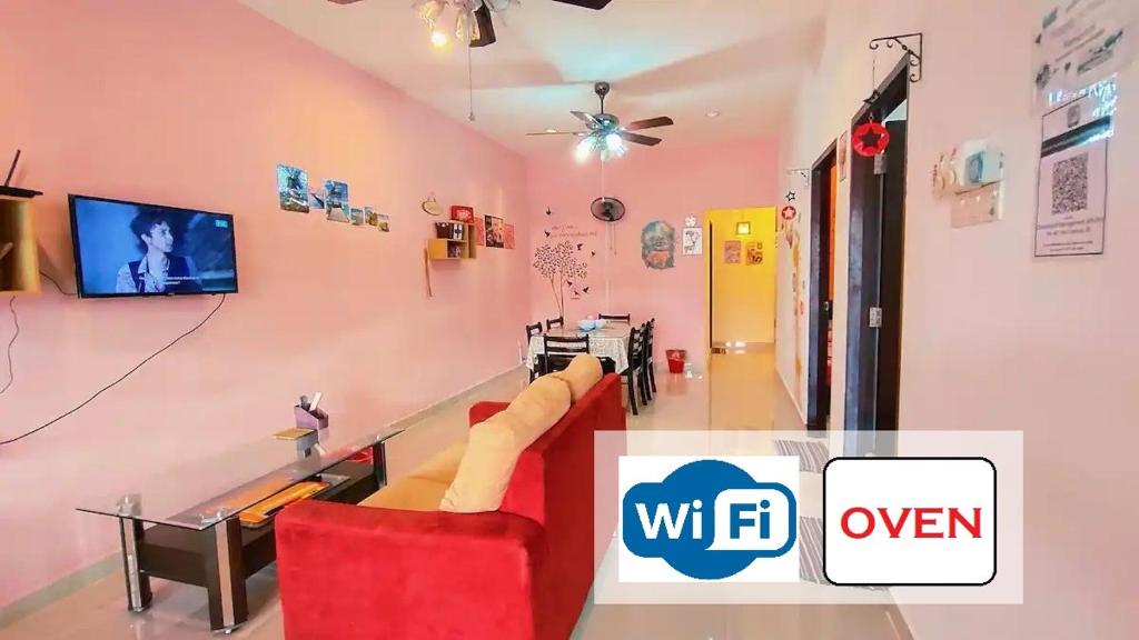 46 Jb Tmn Century 5Room 18pax near CIQ KSL Mall في جوهور باهرو: غرفة معيشة مع أريكة وتلفزيون على الحائط