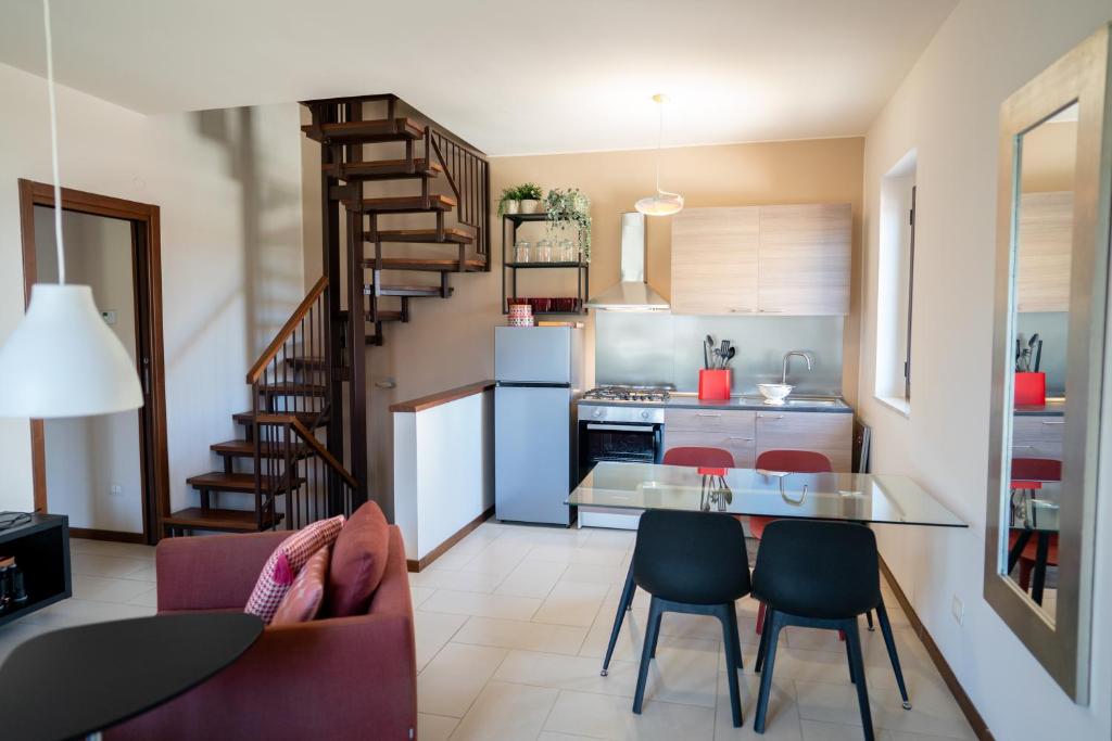 a kitchen and living room with a table and chairs at Casa Terra d'Aci in Aci Bonaccorsi