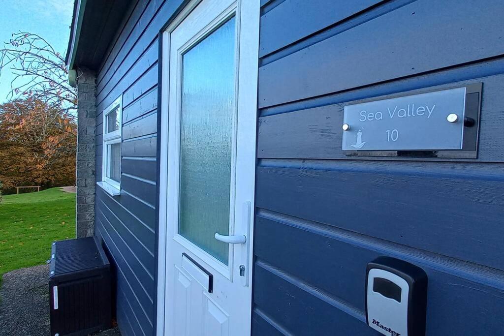 a blue house with a door and a mailbox at 10 Sea Valley in Bideford