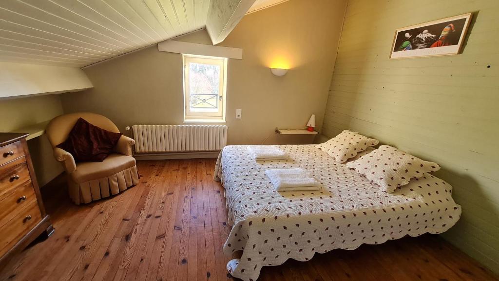 niewielka sypialnia z łóżkiem i krzesłem w obiekcie Gîte de Jambayle w mieście Lafrançaise