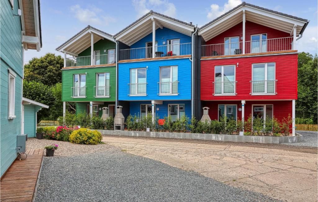 Une rangée de maisons colorées avec des fleurs devant dans l'établissement Seewolke 4, à Süssau
