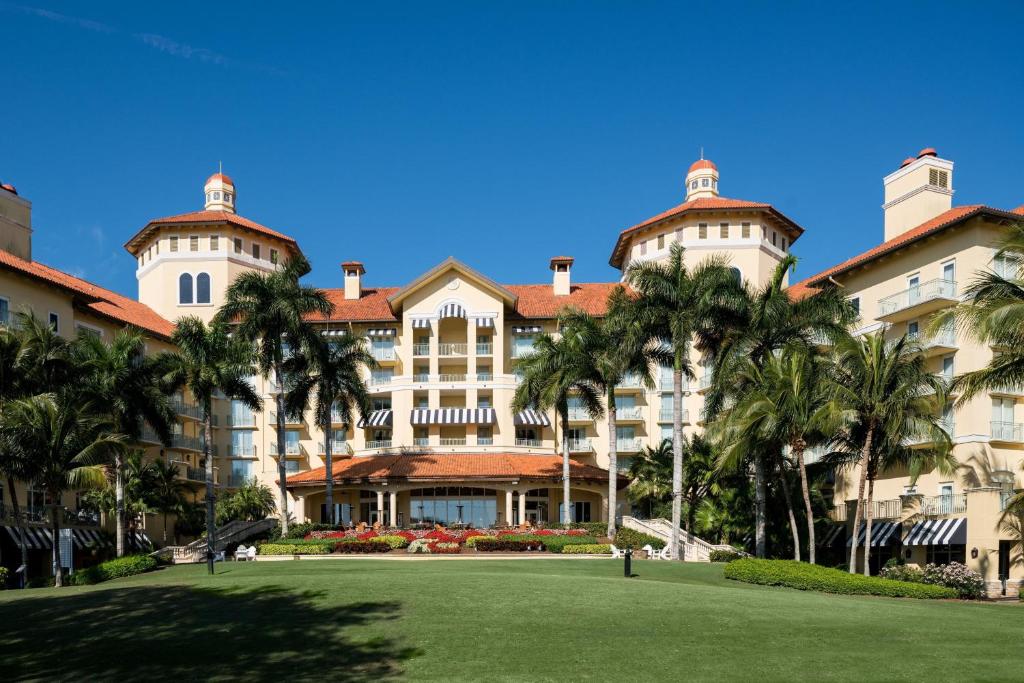 a large building with palm trees in front of it at The Ritz-Carlton Naples, Tiburon in Naples
