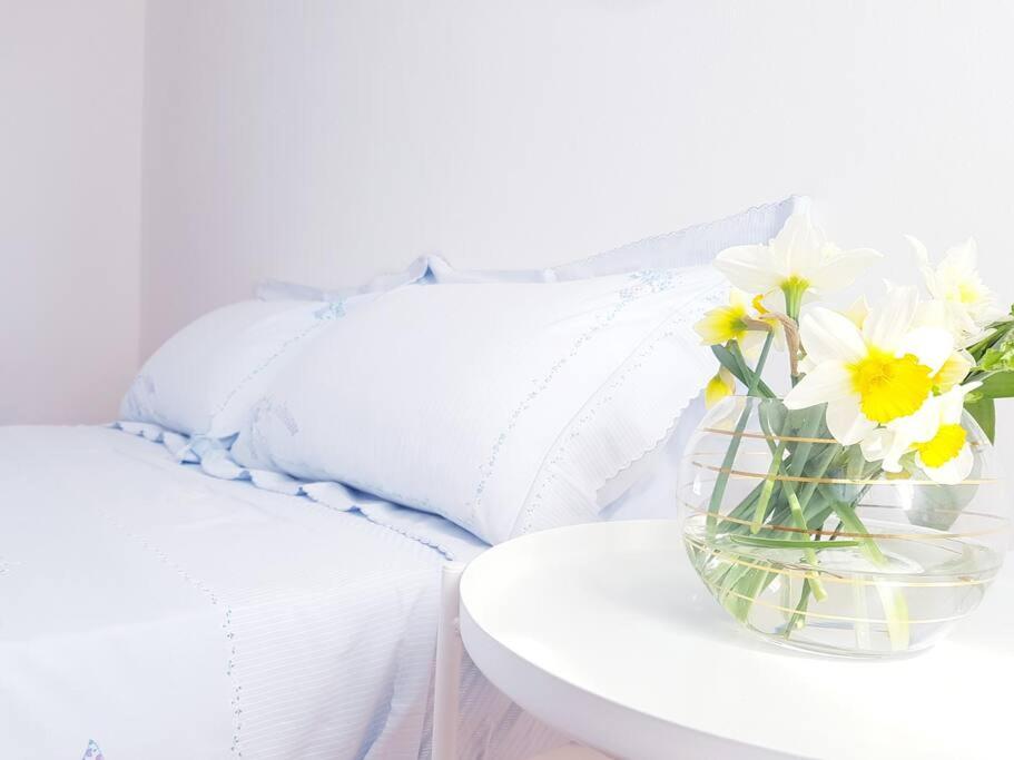 um vaso de flores em uma mesa ao lado de uma cama em Bella's Country House 