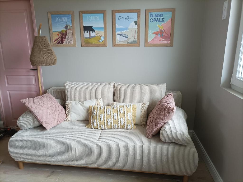 - un canapé blanc avec des oreillers dans l'établissement Détente sur la Côte d'Opale, à Équihen-Plage