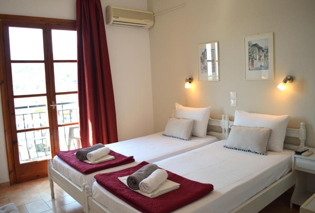 a bedroom with two beds with towels on them at Pension Mando in Skiathos