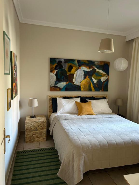 a bedroom with a bed with a painting on the wall at The ART space in Kavala in Kavála