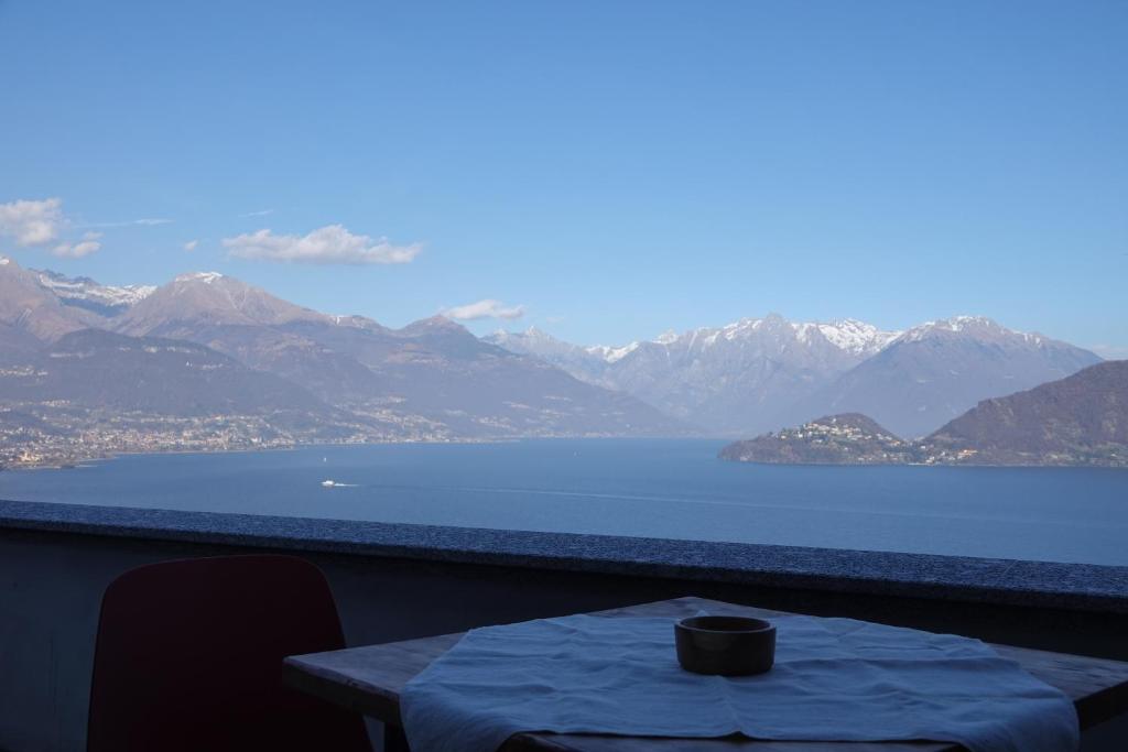 a table on a balcony with a view of the water at Casale Bella.Vista in Pianello Del Lario
