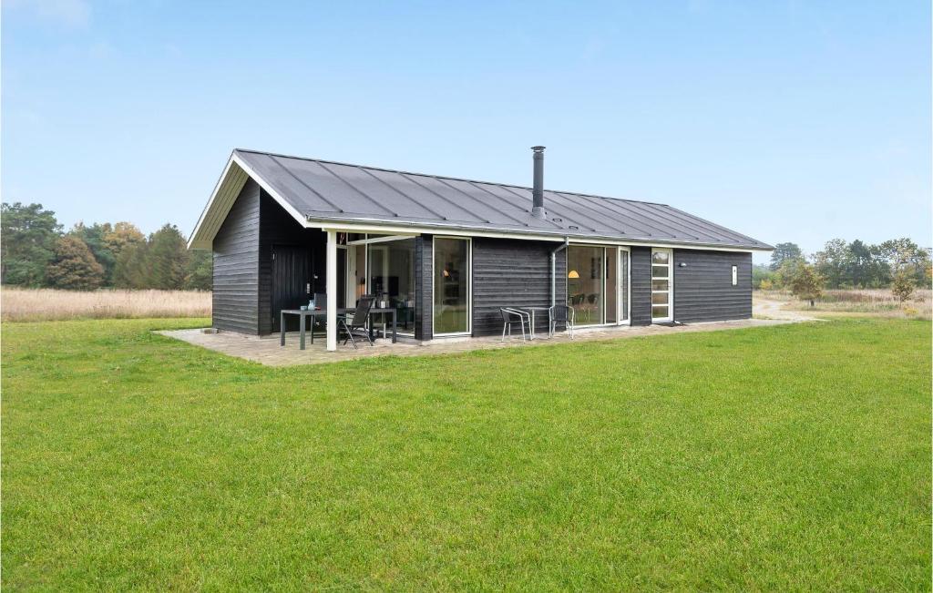 czarny dom na polu z zieloną trawą w obiekcie Pet Friendly Home In Grenaa With Wifi w mieście Brøndstrup
