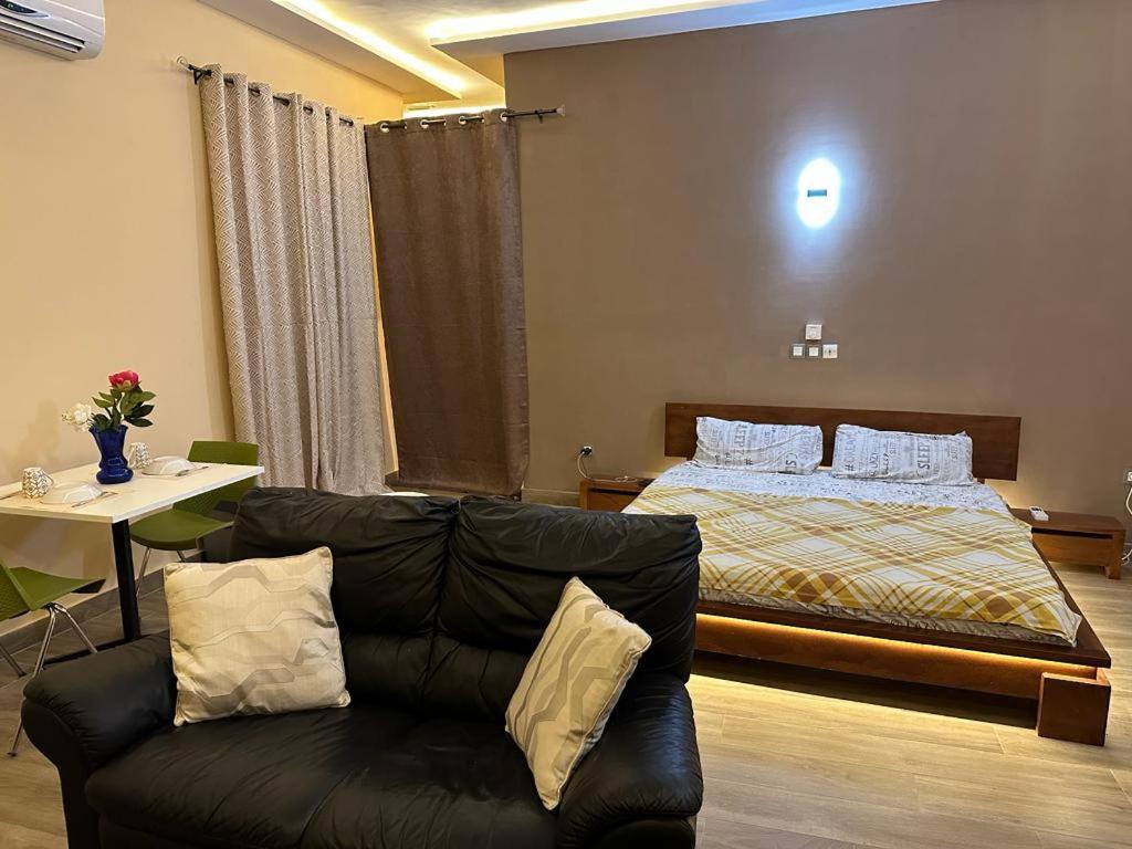 sala de estar con cama y sofá en Les Résidences de Gorée Porto-Novo, en Porto Novo