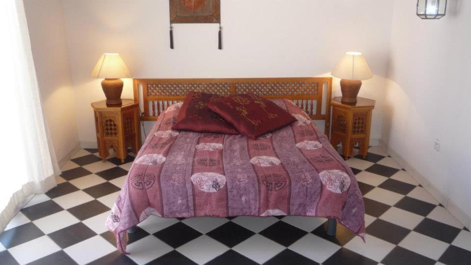 a bedroom with a bed and two night stands with lamps at Residence VILLA MOROSI - Favone in Conca