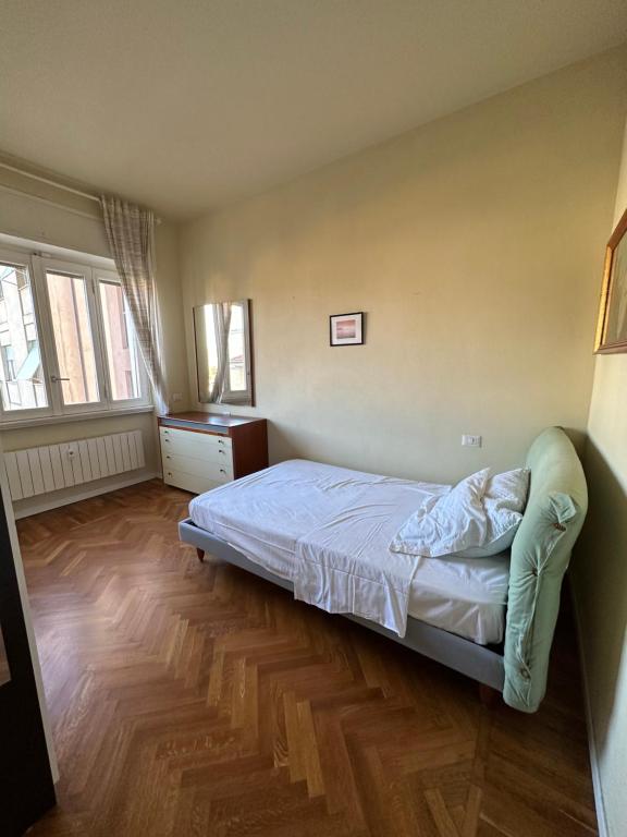 1 dormitorio con 1 cama y suelo de madera en Sweet Home Varese, en Varese
