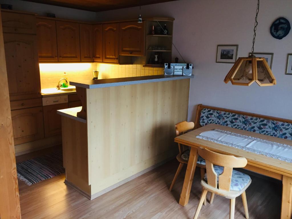 a kitchen with a counter and a table with a chair at Apartment Ebnit in Dornbirn