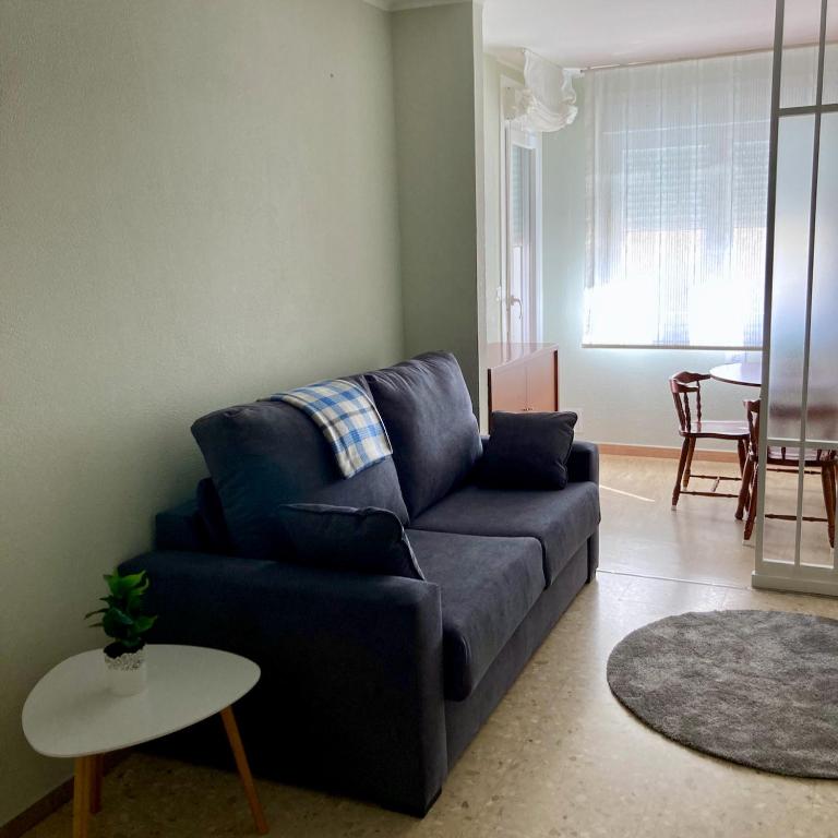 a living room with a blue couch and a table at Playa América Angelito A in Playa América