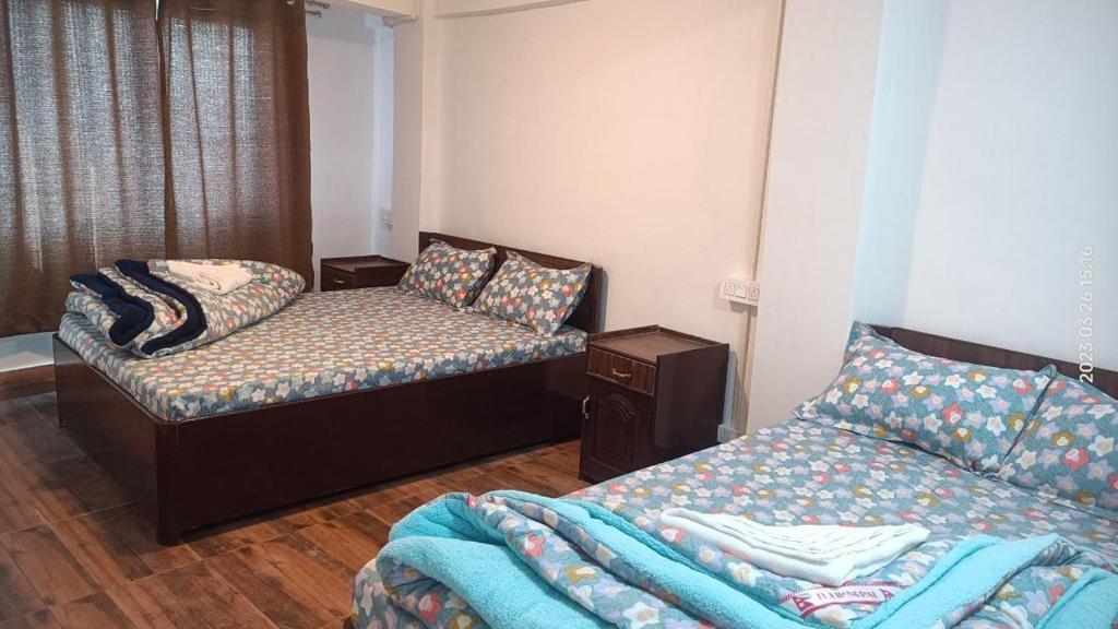 a room with two beds and a couch in it at Darjeeling Homestay Nyano Ghar in Darjeeling