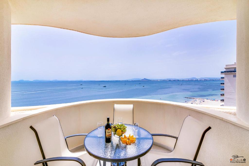 ein Tisch und Stühle auf einem Balkon mit Blick auf das Meer in der Unterkunft Murano by Alina365 in La Manga del Mar Menor