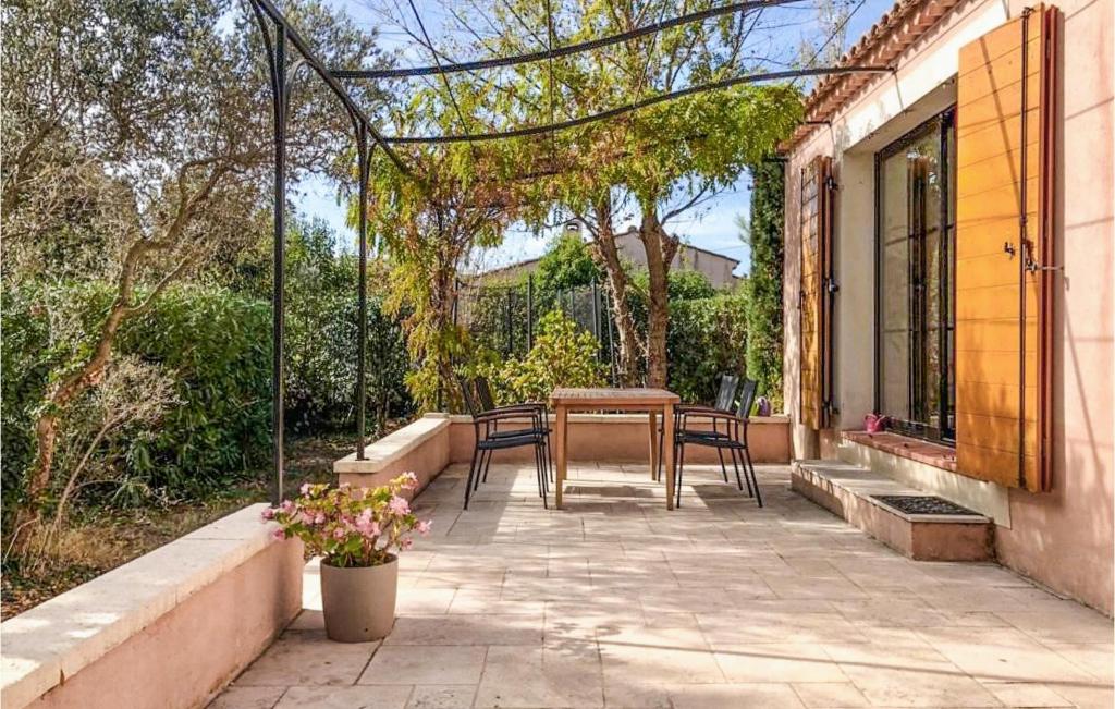 eine Terrasse mit einem Tisch und Stühlen darauf in der Unterkunft Stunning Home In Salon-de-provence With Outdoor Swimming Pool, Wifi And 3 Bedrooms in Salon-de-Provence