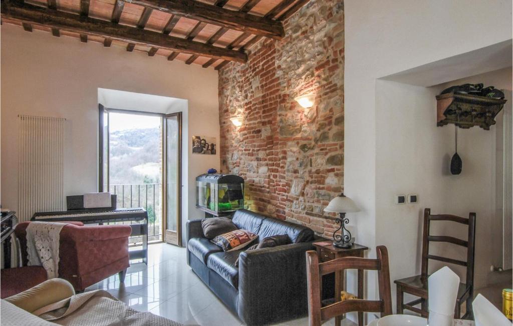 a living room with a couch and a brick wall at Amazing Apartment In Montefortino With Wifi And 2 Bedrooms in Montefortino