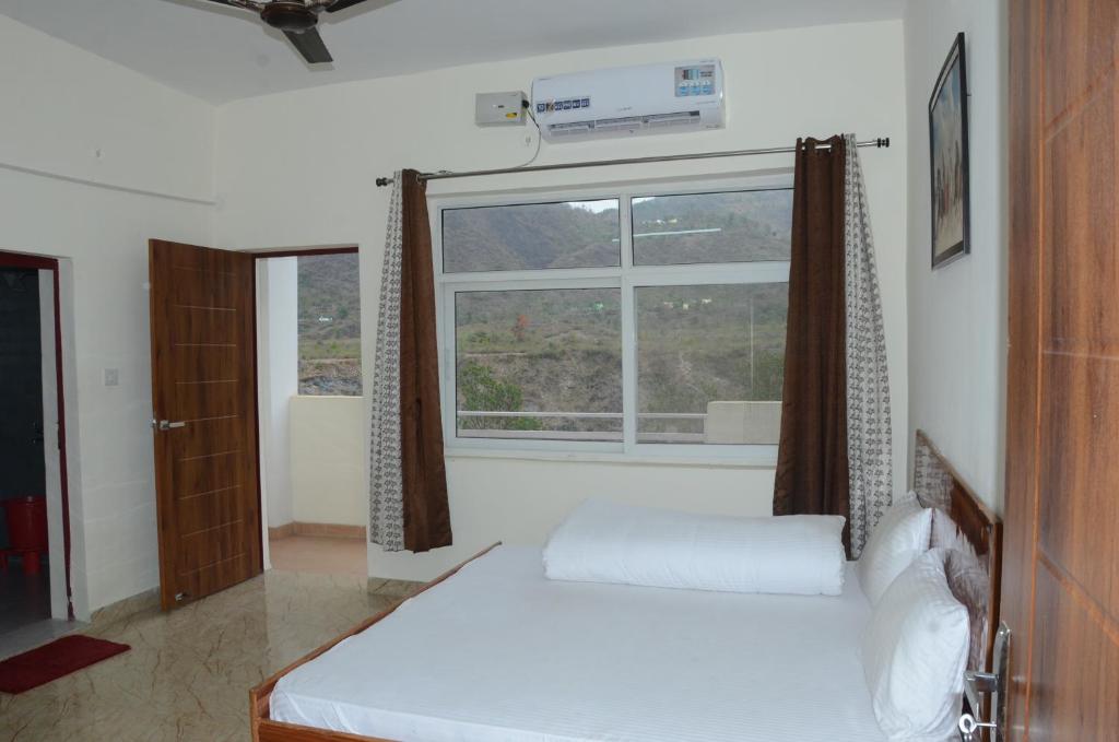 una camera con letto e finestra di Shivalik Riverine Homestay and hotel a Lansdowne