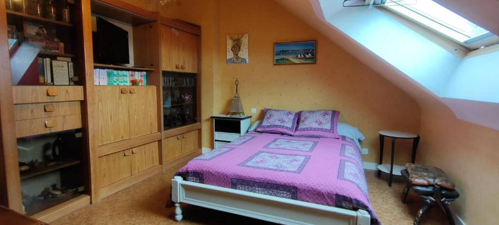 - une chambre mansardée avec un lit violet dans l'établissement Étage indépendant. 2 chambres + cuisine, à Pontivy