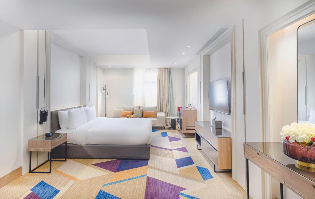 um quarto de hotel com uma cama e uma televisão em Ewaa Express Hotel - Al Jouf em Sacaca