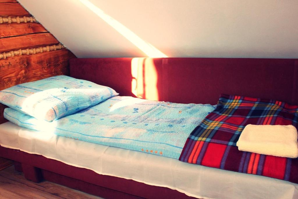 a bed with two pillows on top of it at Domek u Johnnego 27 