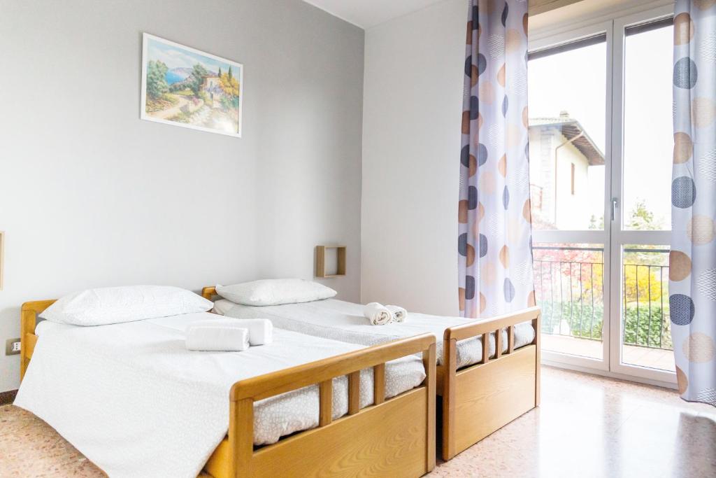 a bedroom with two beds and a large window at La Ginestra - between lake and mountains in Colazza