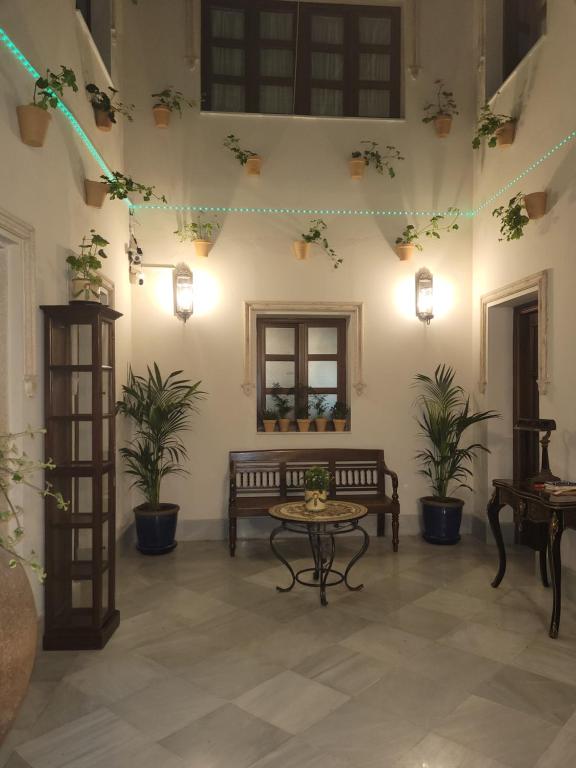 Sala de estar con banco y macetas en Habitaciones La Flamenka en Ronda