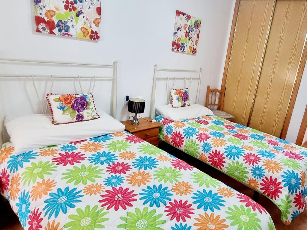 1 dormitorio con 2 camas y sábanas coloridas en Sheron's Apartment, en Los Alcázares