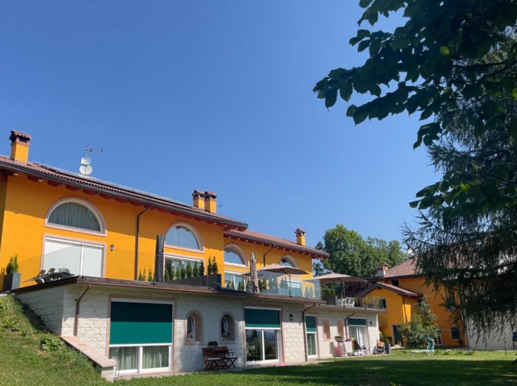 an orange house with a balcony on top of it at Agriturismo Lambra La Casa Del Sol in Asiago