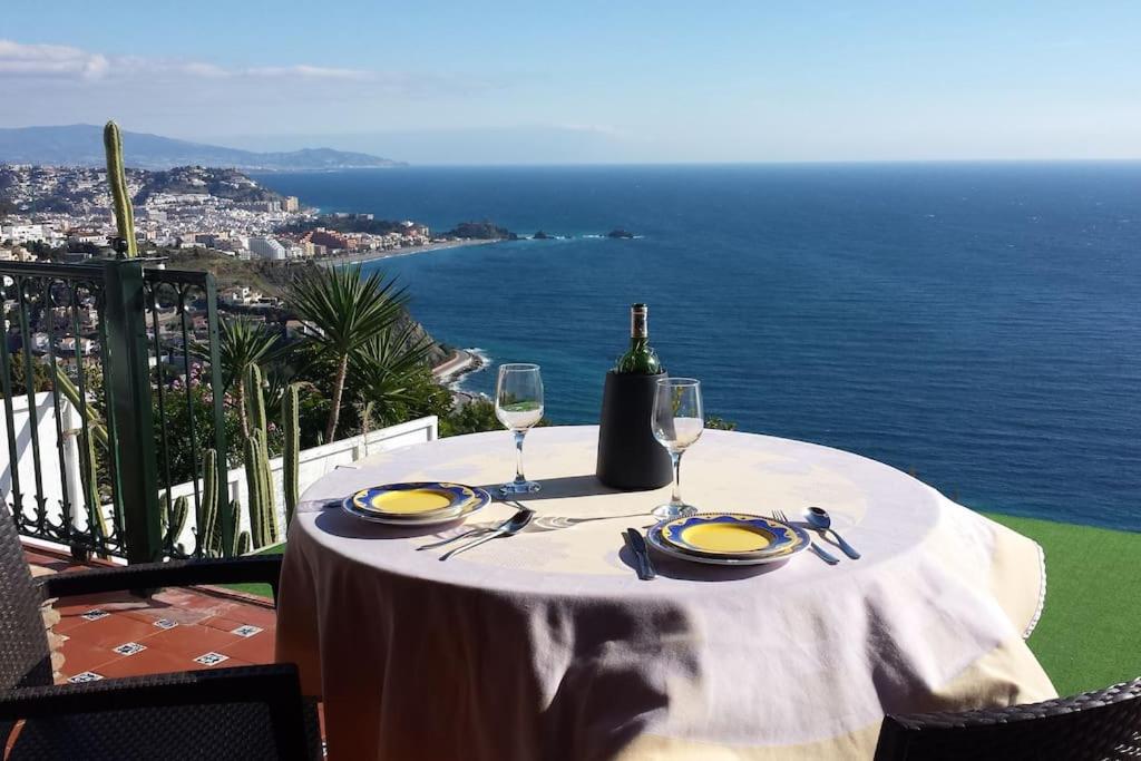 a table with a bottle of wine and two glasses at Blue Horizon Apartment in Granada