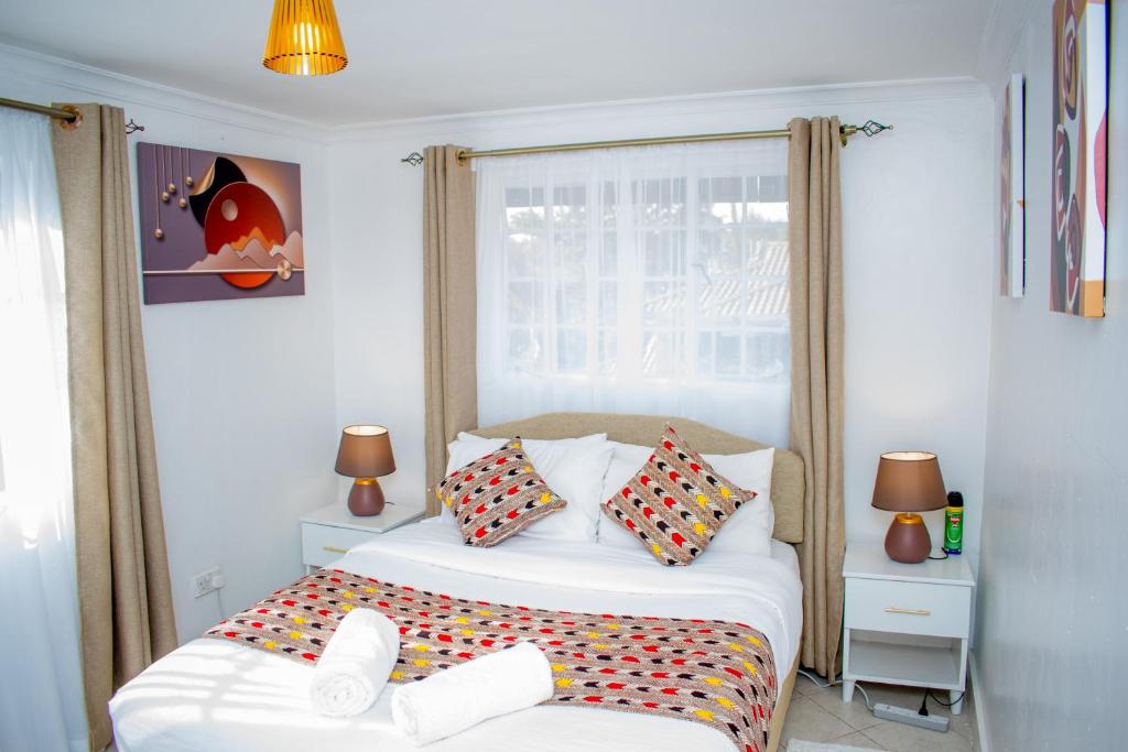 een slaapkamer met een bed met kleurrijke kussens bij 16 Arabella Residence near Waterfront Mall - Karen in Karen